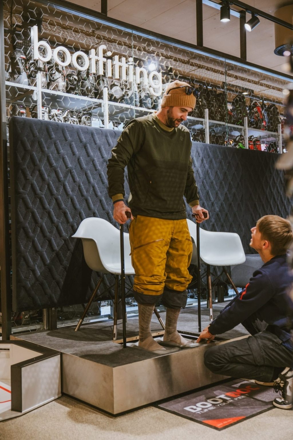 Schuhfitting im FREUDENHAUS Obertauern: Kunde steht auf dem Messpodest, Mitarbeiter passt den Skischuh an