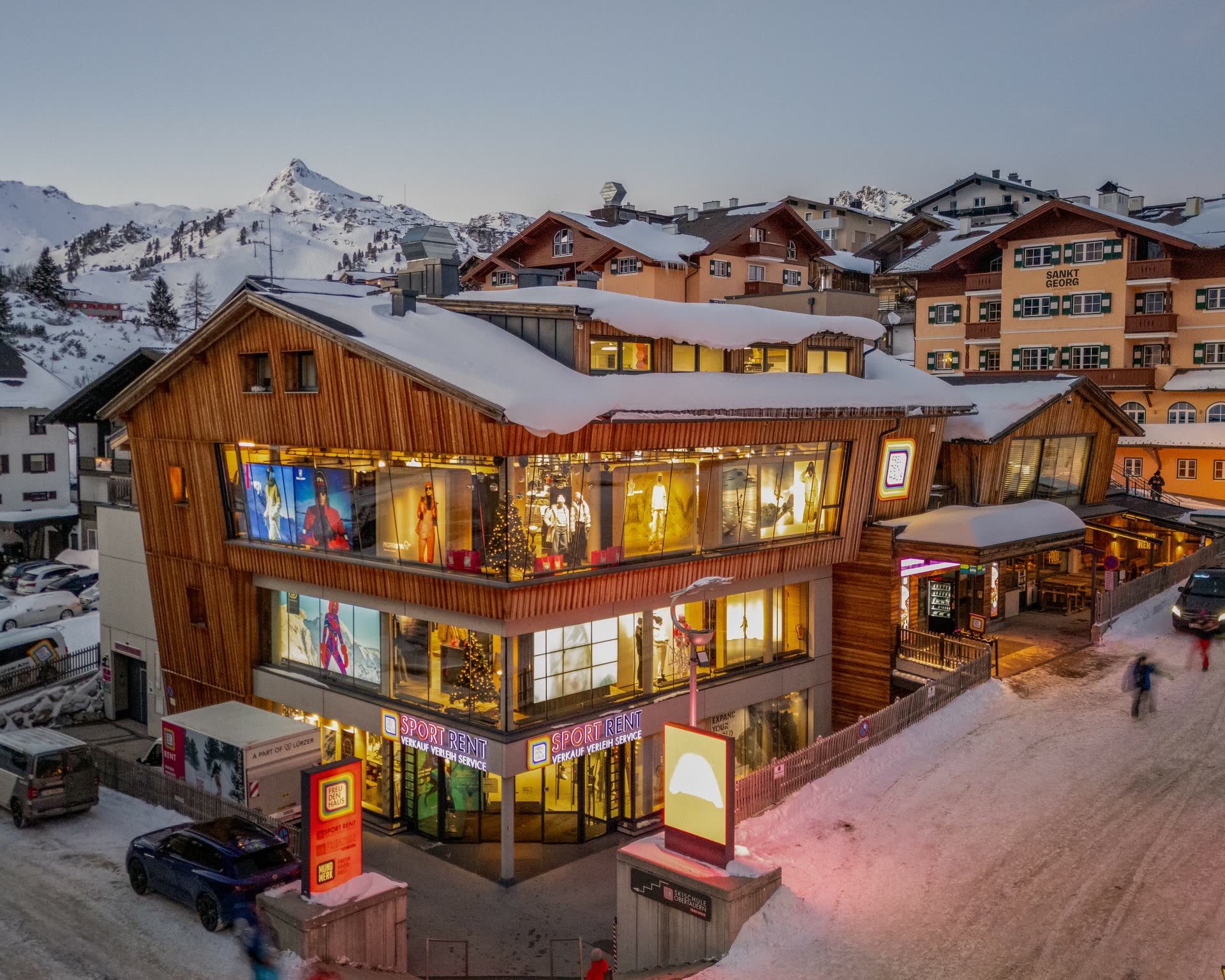 FREUDENHAUS shop in Obertauern bij avondlicht, verlichte houten gevel