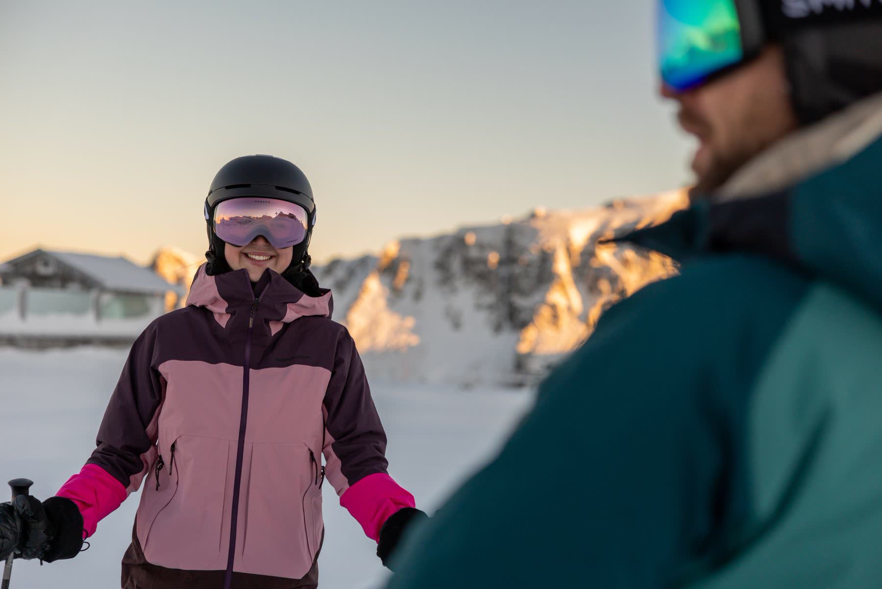 Skiër lacht voor het bergpanorama in Obertauern in het avondlicht